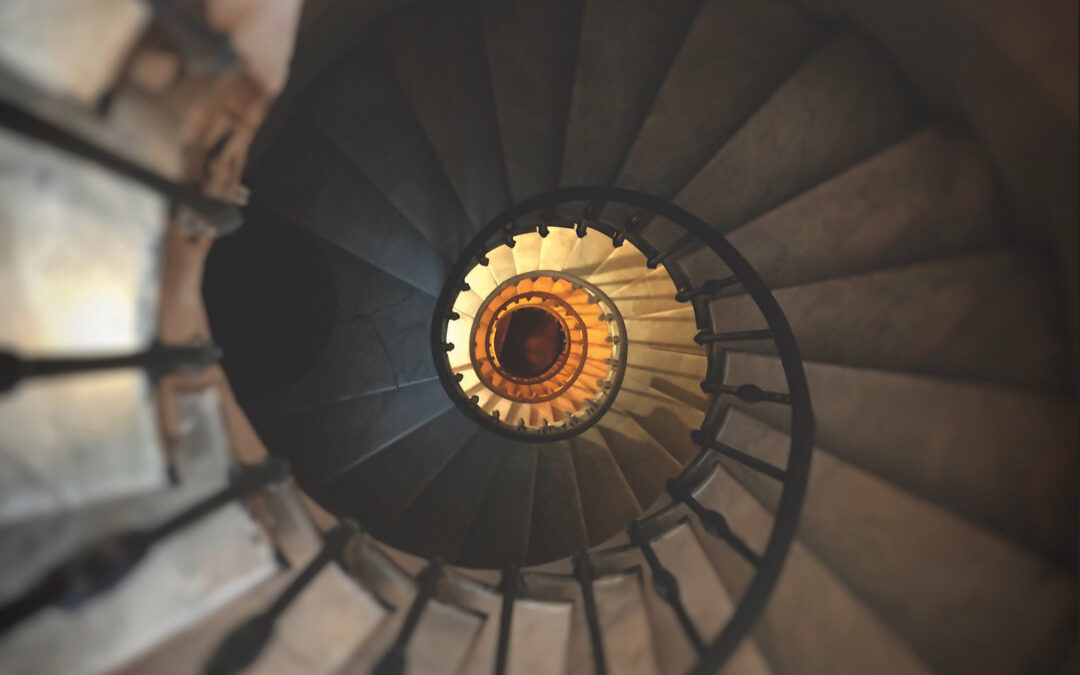 ancient spiral staircase with wrought iron handrail and marble steps