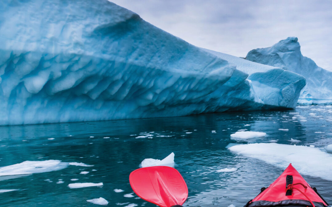 Kayaking in Antarctica between icebergs with inflatable kayak, extreme adventure in Antarctic Peninsula , beautiful pristine landscape, sea water paddling activity