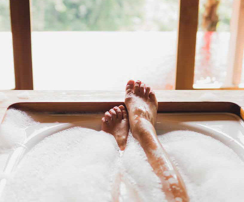 Woman legs in bath foam. Enjoying and relaxation in spa hotel ro
