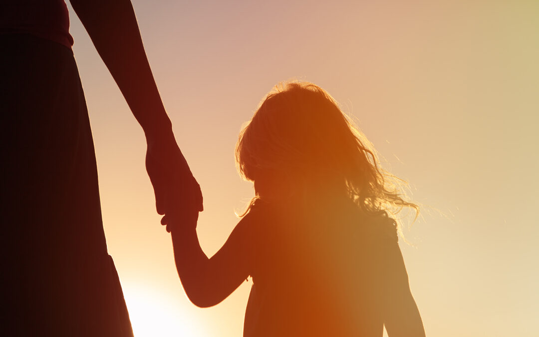 Silhouette,Of,Mother,And,Daughter,Holding,Hands,At,Sunset