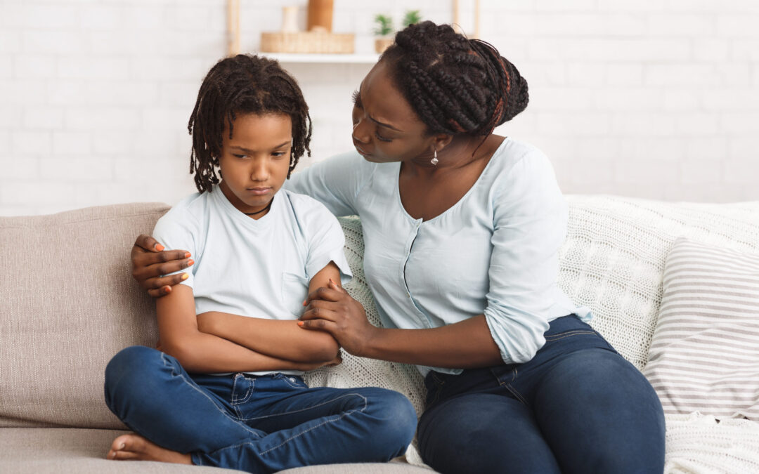 Black woman apologizing to her grumpy child